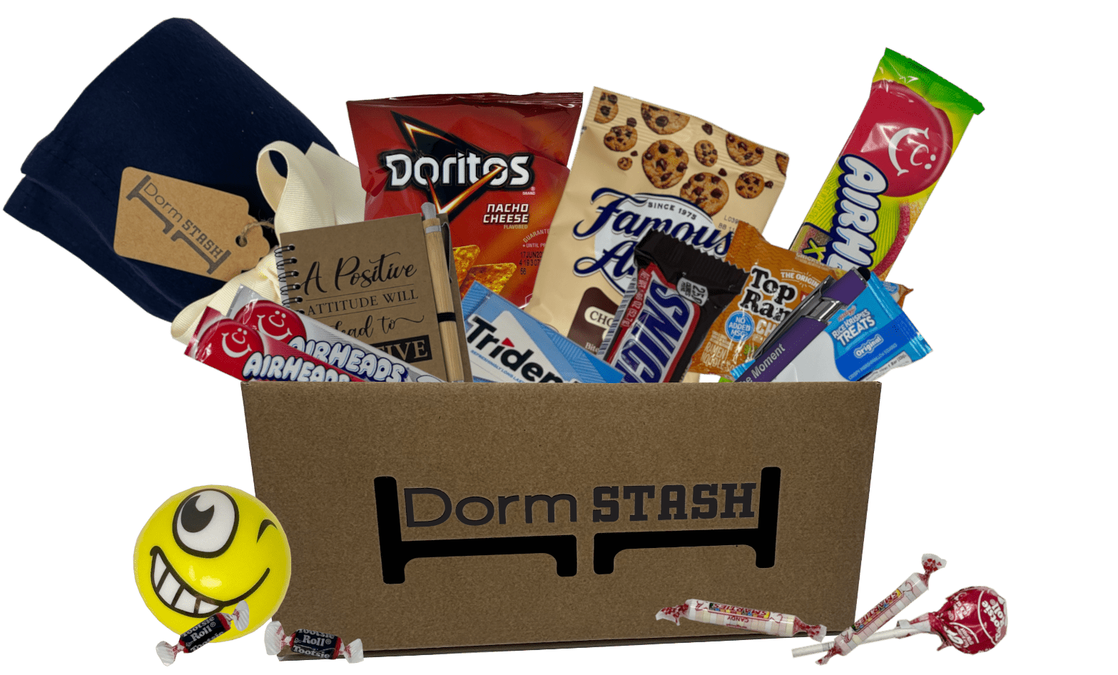 The "Care Package Monthly" includes a cardboard box labeled "Dorm Stash," filled with snacks, a cozy blanket, and a cheerful stress ball. Outside the box, you'll find scattered assorted candies and gum.